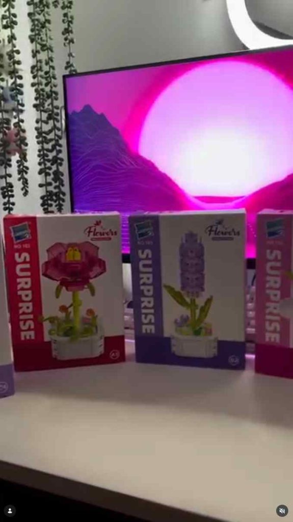 Building block sets on a shelf lit with pink light