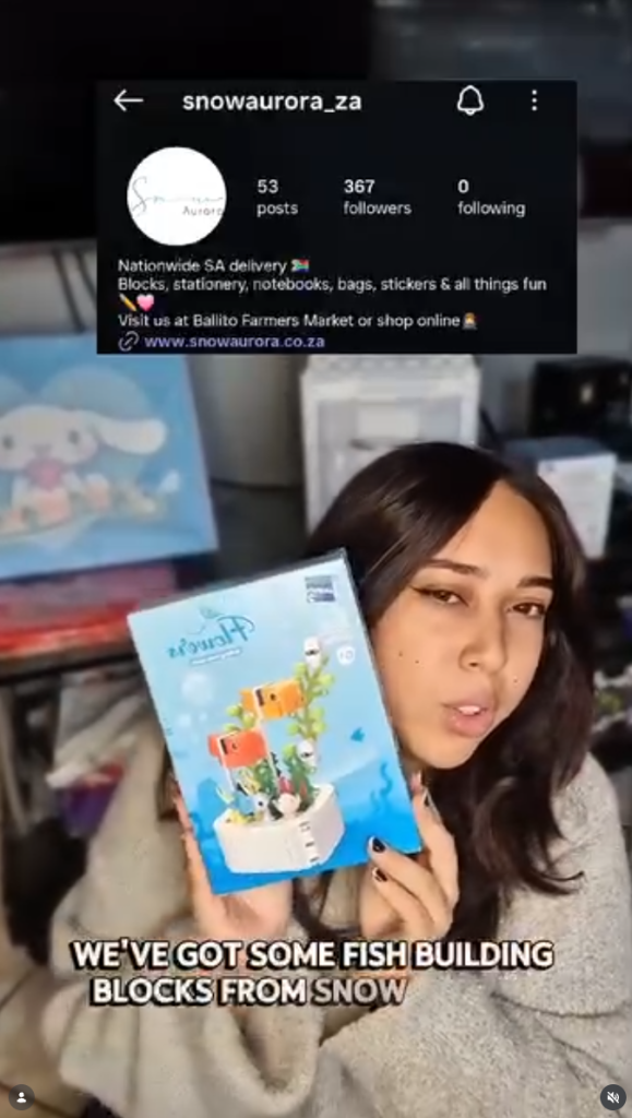 Woman holding a boxed building blocks set while unboxing it